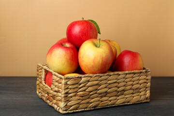 Basket with red apples on dark wooden table