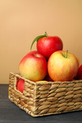 Basket with red apples on dark wooden table