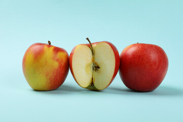 Ripe apples on blue background, close up