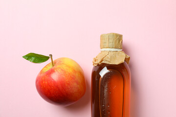 Homemade apple vinegar and ingredient on pink background
