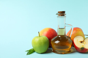 Homemade apple vinegar and ingredients on blue background