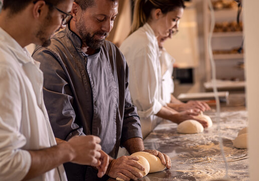 Bakers preparing dough for baking bread in modern manufacturing.