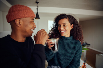 African American couple drinking coffee. Mixed race couple looking at each other in the kitchen at home. High quality photo