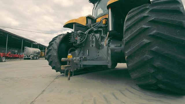 Tractor wheels and transmission operation. View of the tractor from below. Repair of large dimensional equipment.