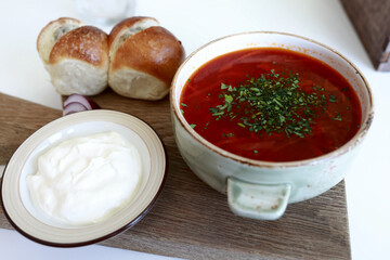 Bowl of borscht with sour cream and buns
