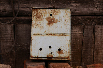 An old rusty mailbox sits in a landfill