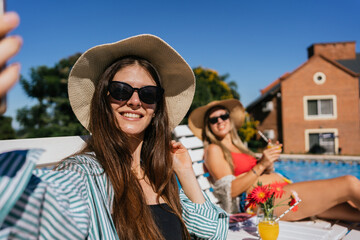 Portrait of young women enjoying the sun by the pool.