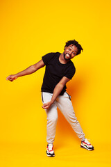 young handsome african american guy student posing cheerful and gesturing on yellow background, lifestyle people concept