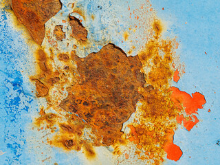 Rusty surface of metal plate with blue cracked color paint.