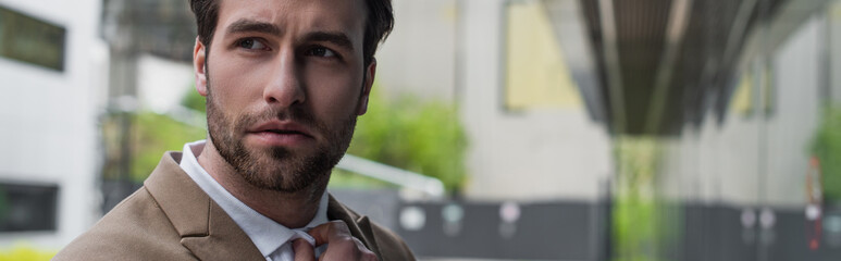 Fototapeta premium young worried businessman looking away outside, banner.