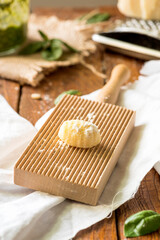 Detail of one uncooked gnocco  on wooden board