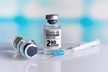 Vaccine bottles identified with first and second dose labels for covid-19 immunization. Two COVID-19 Vaccine Vials tagged with 1st and 2nd dose for vaccination of patients
