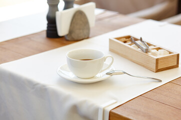 Hot coffee in a cup on wooden table. Modern design interior, restaurant blur background with bokeh image