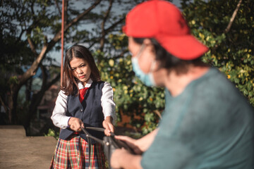 A brave young woman resists and fights off a snatcher trying to take her bag while walking outdoors.
