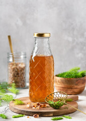 Bottle of homemade syrup made from young spruce tips and nature sugar on the wooden cutting...