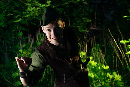 A large portrait of cosplay on Peter Pan against the backdrop of the woods at night