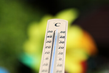 Thermometer shows high temperatures on a hot summer day