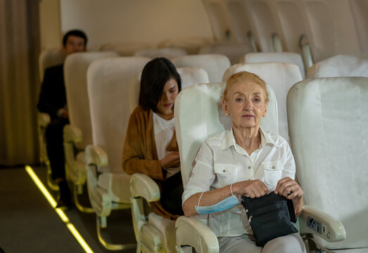 Passenger Elderly Woman Of Commercial Airplane On Their Seats During Flight,Travel Concept.