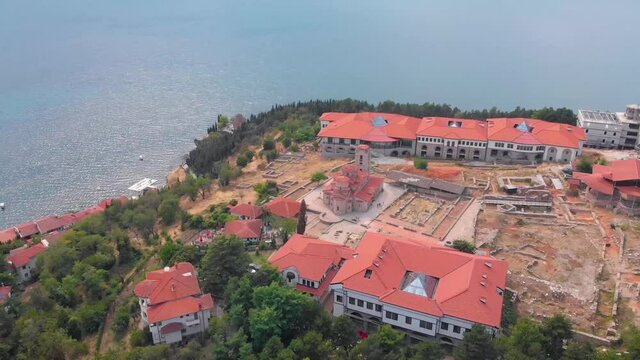 Orthodox church at old town of Ohrid, North Macedonia and village of houses with red roofs. Medieval old gothic architectures look beautiful from above sky with aerial drone 4K 30fps. 