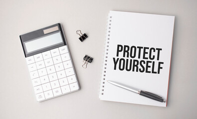 The word PROTECT YOURSELF is written on a white background next to a pen ,calculator and reports. Business concept
