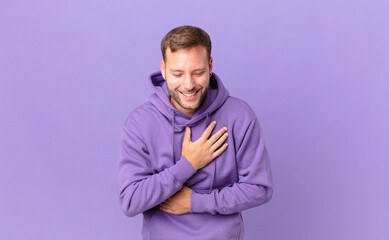 handsome blonde man laughing out loud at some hilarious joke