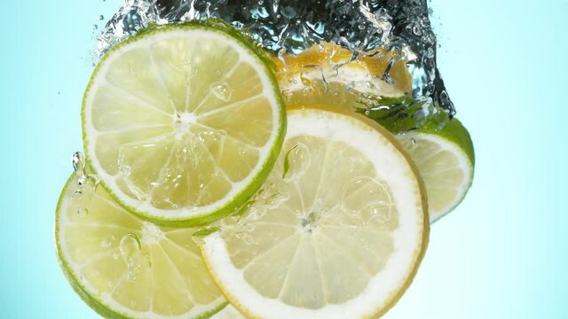 Super slow motion of falling lime and lemon slices into splashing water. Filmed on high speed cinema camera, 1000 fps.