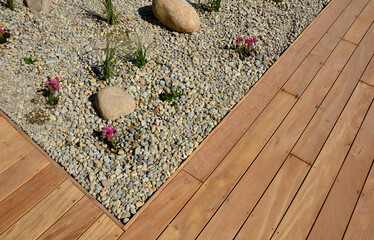 ornamental flowerbed with perennials and stones made of gray granite, mulched pebbles in the city...