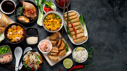 Assorted Chinese dishes and snacks on dark gray background. Traditional food concept.