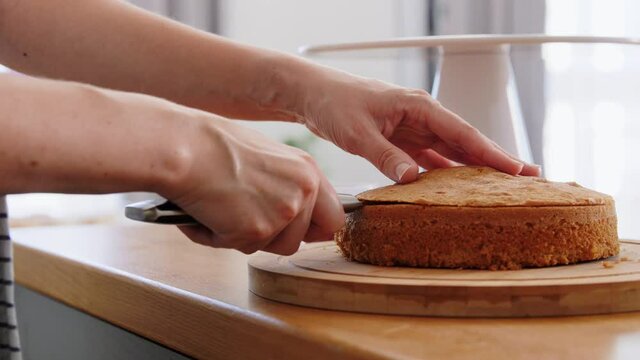 culinary, baking and cooking food concept - young woman making layer cake on kitchen at home