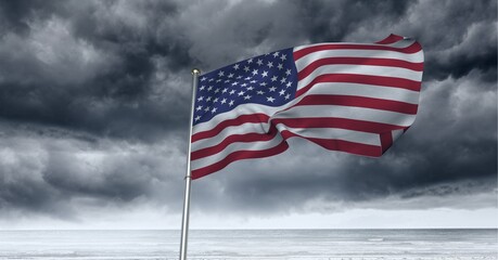 Composition of waving american flag against stormy sky and seaside