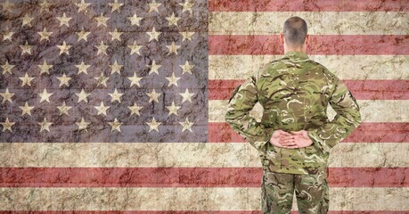 Composition of soldier standing against american flag
