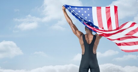 Composition of male athlete holding waving american flag against clouds on blue sky