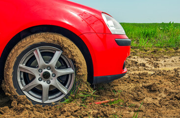 The red car stuck in the mud. Can not fall out of the mud