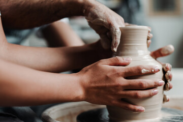Close up photo. Hands of a man make a vase of clay in a clay workshop at a master class