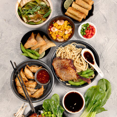 Assorted asian dishes and snacks on dark gray background. Traditional food concept.