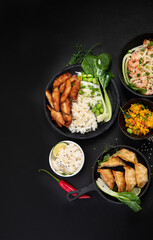 Assorted asian dishes and snacks on black background. Traditional food concept.