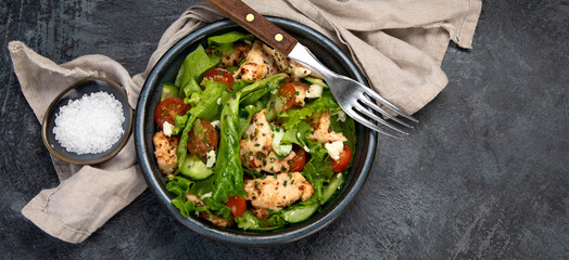 Fresh chicken salad on drak gray background. Healthy food concept.