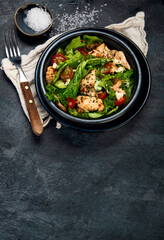 Fresh chicken salad on drak gray background. Healthy food concept.