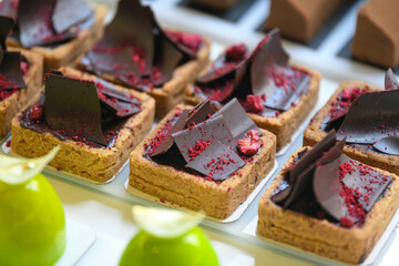 Pastry shop glass display with selection of sweets and cakes. Confectionery shop display background. Delicious sweet treats variety. Small buisness concept.