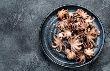 Grilled seafood variety with vegetables on dark background.