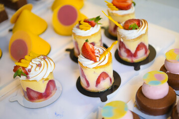 Pastry shop glass display with selection of sweets and cakes. Confectionery shop display background. Delicious sweet treats variety.  
Fraisier cake with fresh fruits. Small buisness concept.