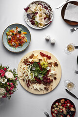 Assorted food, banquet table with snacks, Italian appetizers on a white table, top view, assorted sausages, assorted cheeses, wine, pickled vegetables