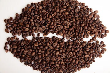 Roasted coffee beans laid out in the form of a large coffee grain close-up