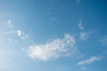 Blue sky with light fluffy white clouds. Perfect natural sky background for your photos