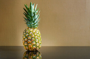 Fresh pineapple over brown wall background