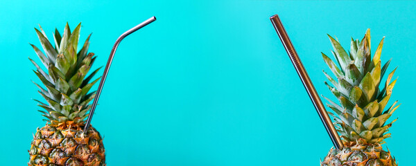 Summer party background with pineapple juice with a straw over blue background