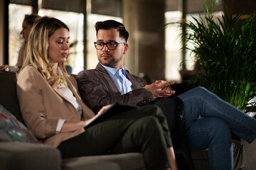 Colleagues talking in the office. Businesswoman and businessman laughing in the office