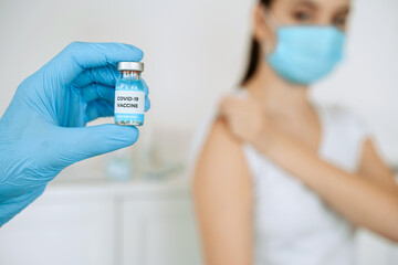 Hands of medical staff in blue glove hold injecting covid-19 vaccine for coronavirus immunization...