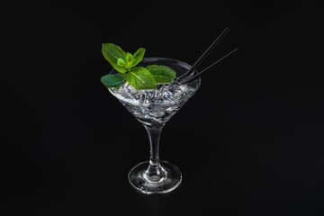 Cocktail with ice and mint on a black background.