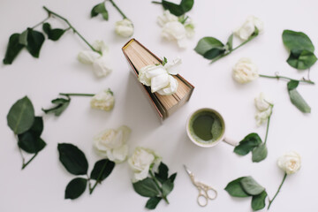 Fototapeta na wymiar Beautiful romantic composition with cup of matcha green tea and rose flowers on white background. Flatlay, top view